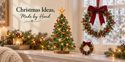 Cozy Christmas window scene with a light-up beaded tree, glass-bead wreaths, burgundy bows, evergreen branches, and warm lights