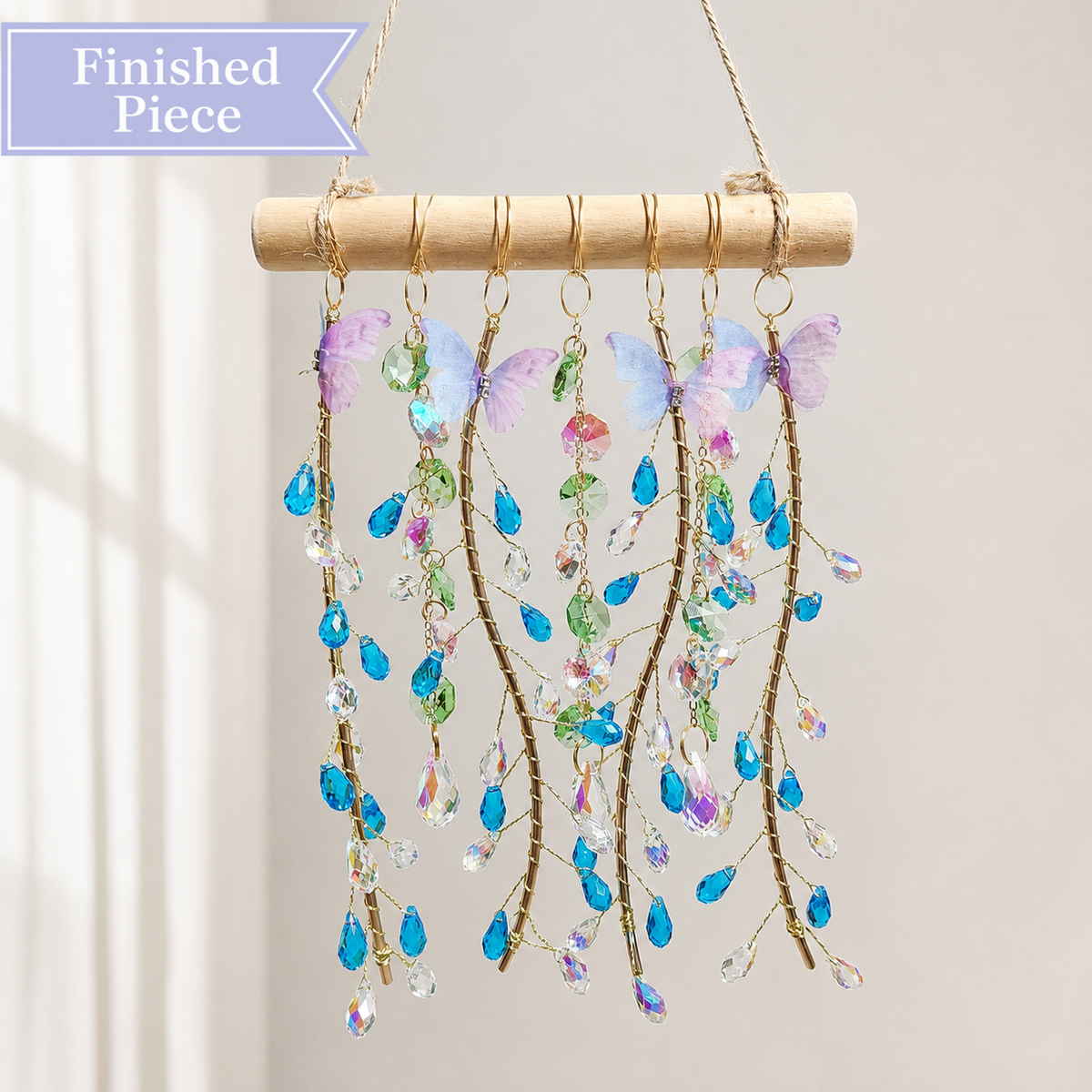 Ocean Willow finished suncatcher with blue teardrop crystals, pastel butterflies, and natural wood.