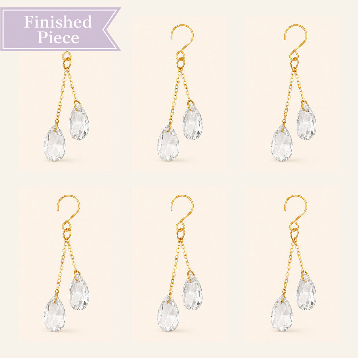 Six clear crystal plant vine suncatcher charms with gold-tone hooks arranged on a warm ivory background.