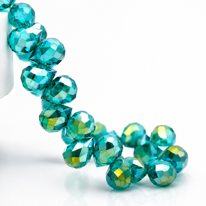 Close-up of Teal Green faceted teardrop glass beads with an iridescent finish