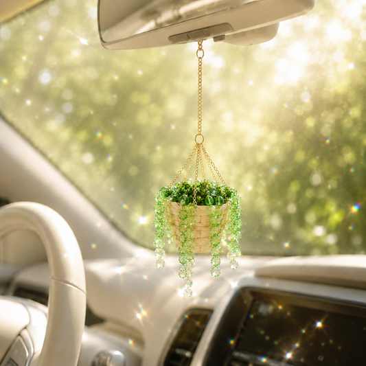 Mini green finished beaded plant car charm hanging inside a sunlit car.