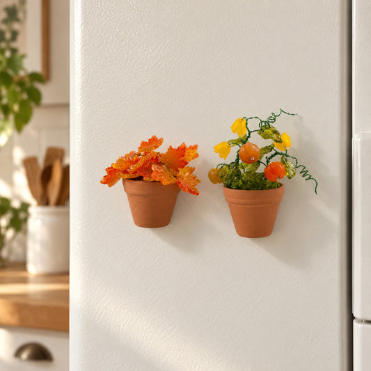 Pumpkin and maple leaf mini beaded plant magnets displayed together on a refrigerator door