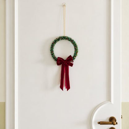 Large Slim 21 cm beaded Christmas wreath with red velvet bow hanging on a door