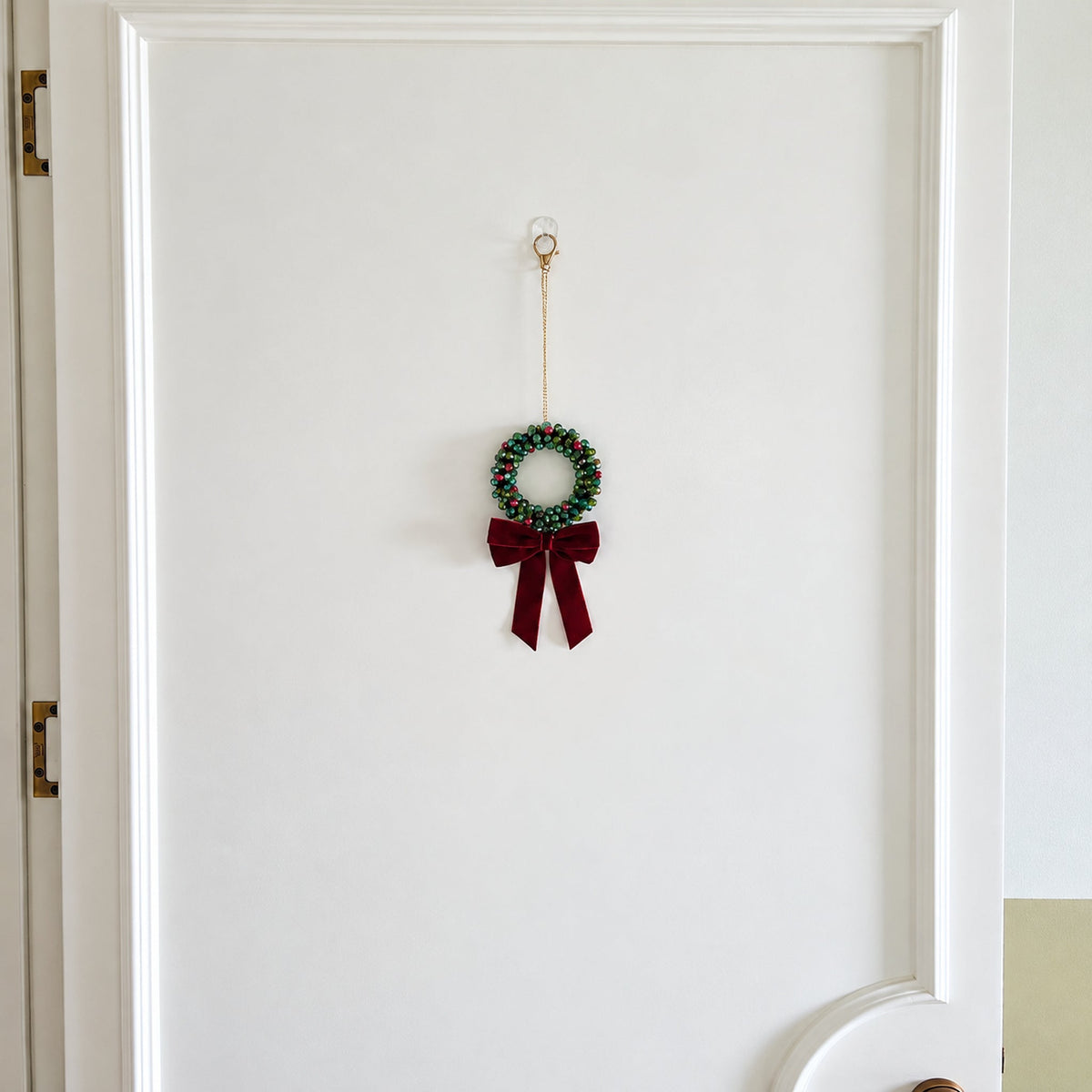 Mini 9 cm beaded Christmas wreath with 160 beads hanging on a door
