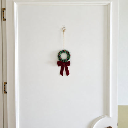 Mini 9 cm beaded Christmas wreath with 160 beads hanging on a door
