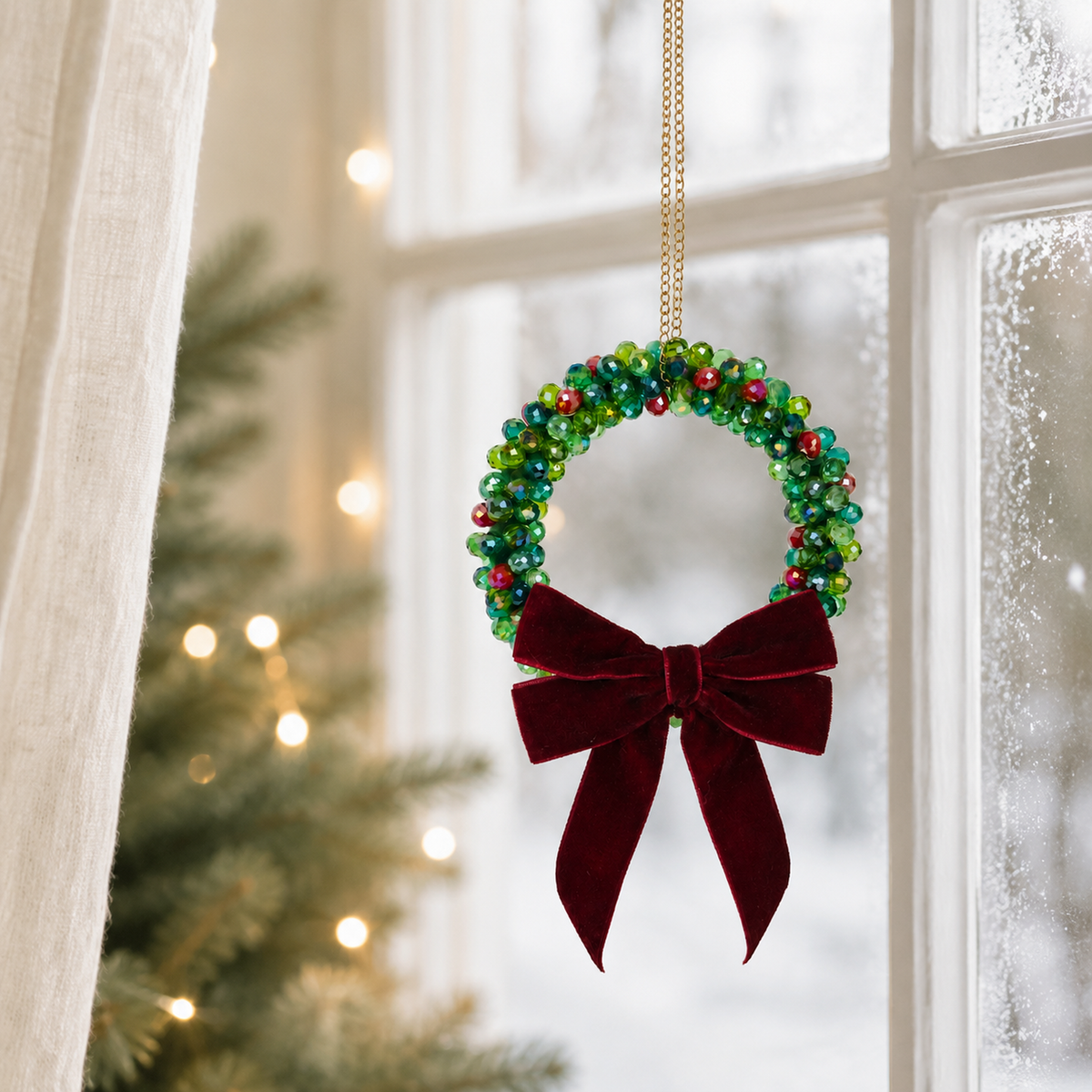 Beaded Christmas wreath glowing with warm fairy lights, finished with a burgundy velvet bow