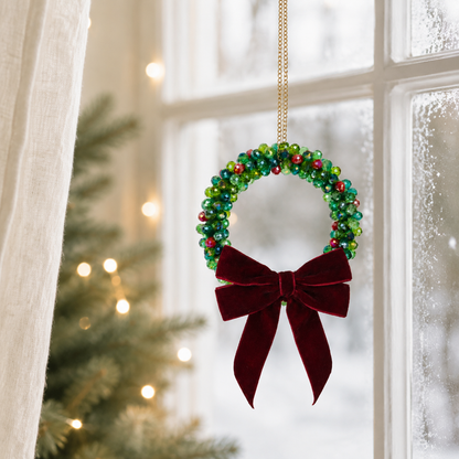 Beaded Christmas wreath glowing with warm fairy lights, finished with a burgundy velvet bow