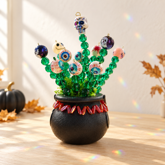 Halloween witch cauldron beaded plant on a bright cream Halloween tabletop