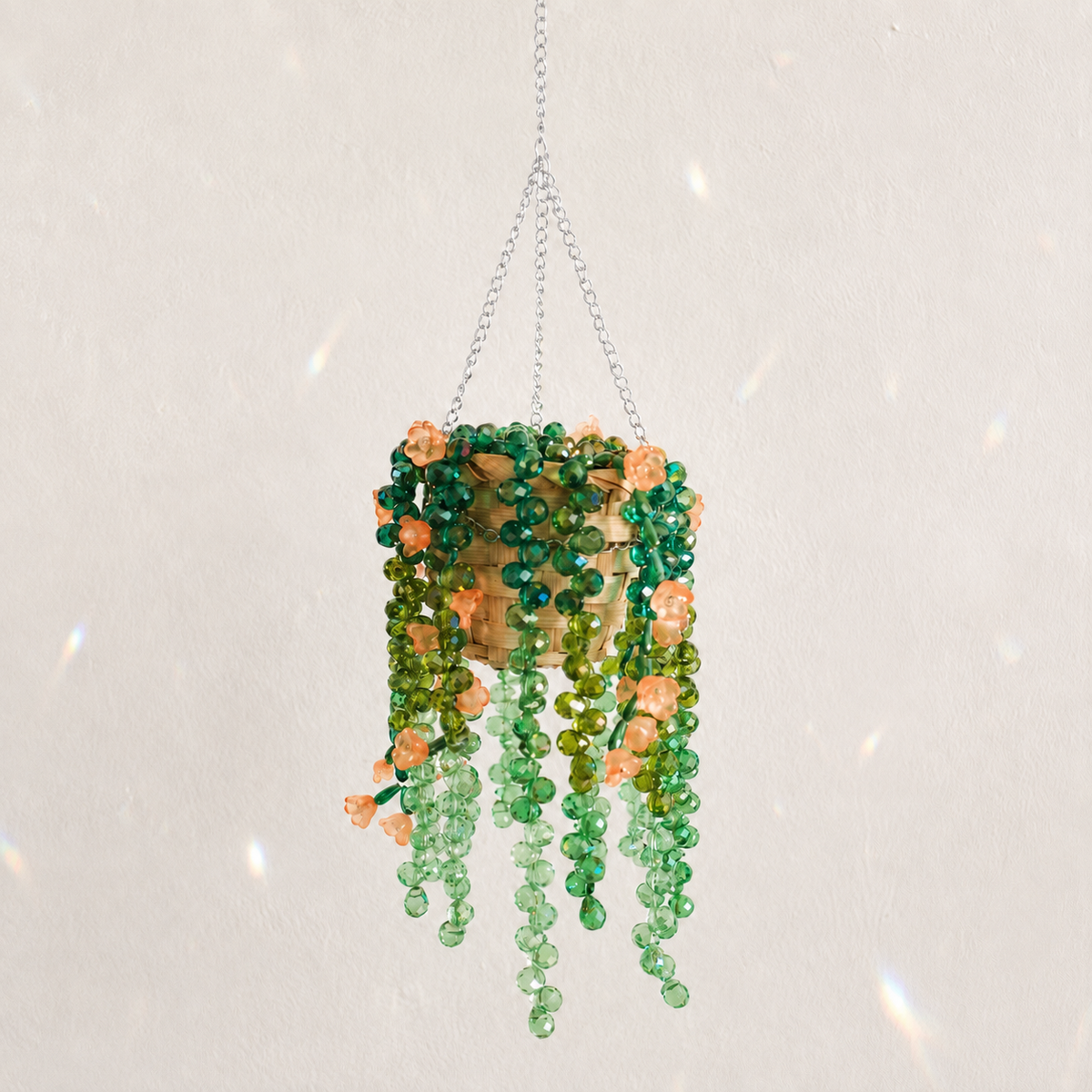 Cascading green beaded hanging plant with peach orange flower beads and a silver chain
