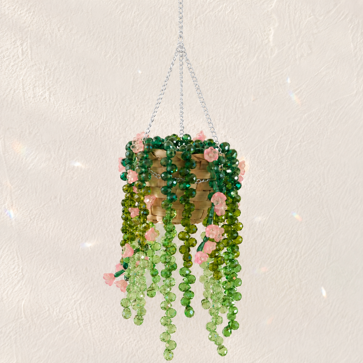 Cascading green beaded hanging plant with blush pink flower beads and a silver chain