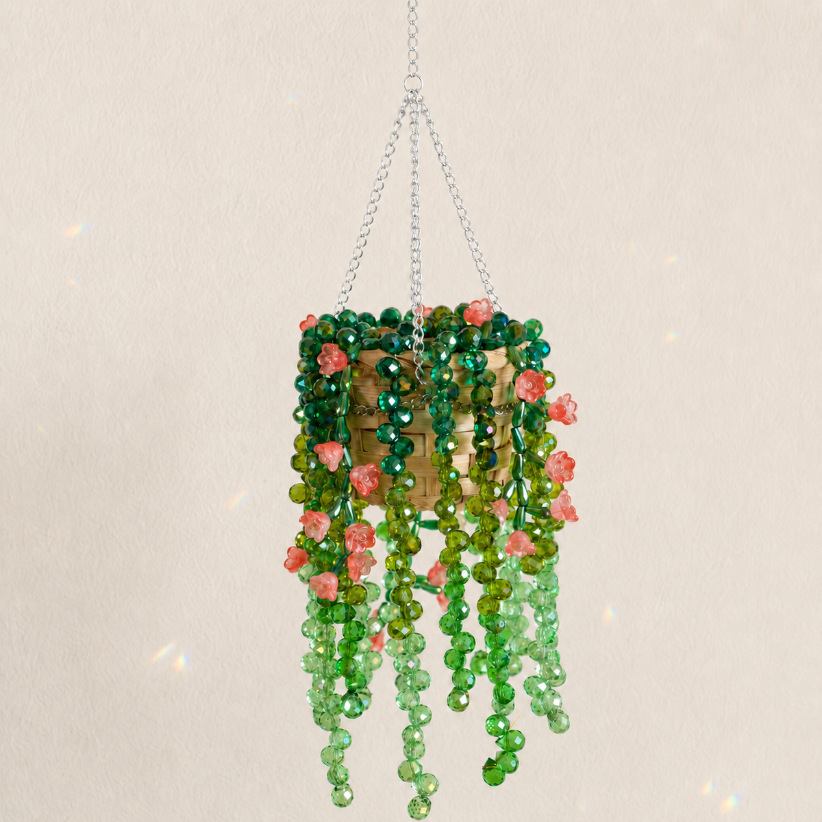 Cascading green beaded hanging plant with coral red flower beads and a silver chain