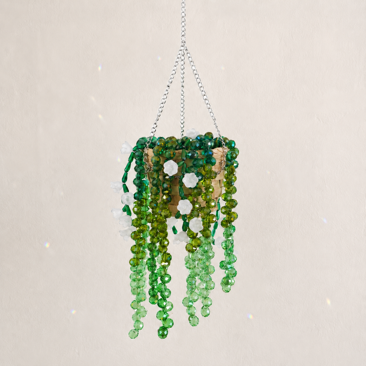 Cascading green beaded hanging plant with translucent white flower beads and a silver chain