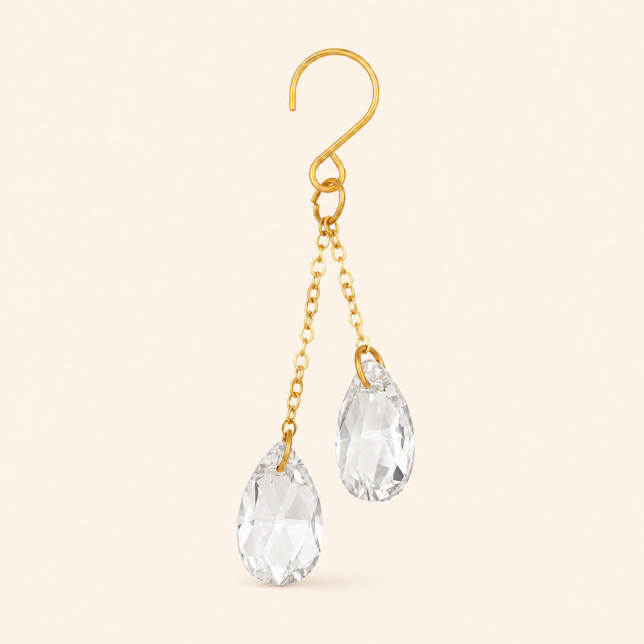 Close-up of one clear crystal plant vine charm with a gold-tone hook, two chains, and two faceted teardrop prisms.