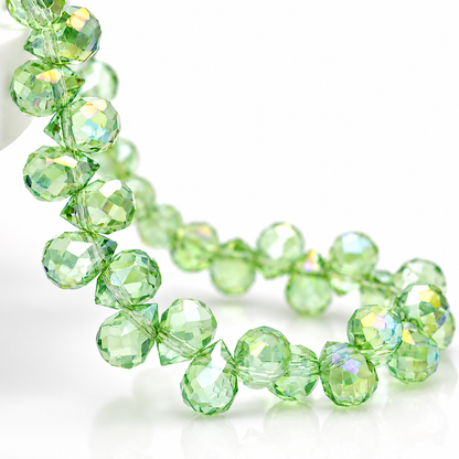 Close-up of translucent Apple Green faceted teardrop glass beads