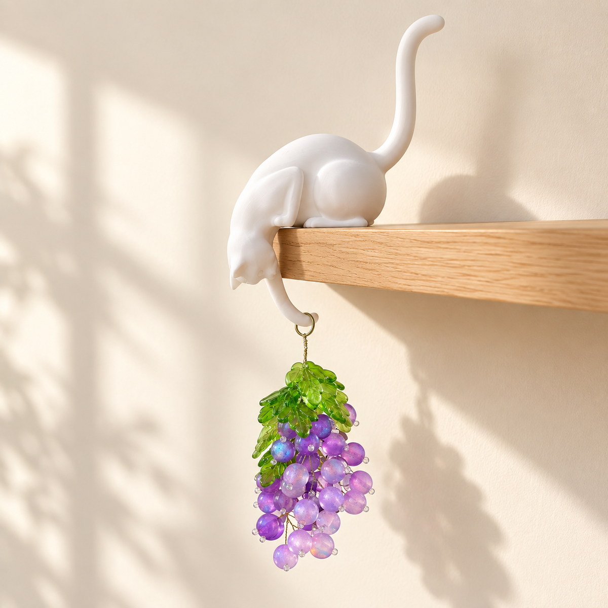 Cat shelf sitter holding a beaded grape bunch