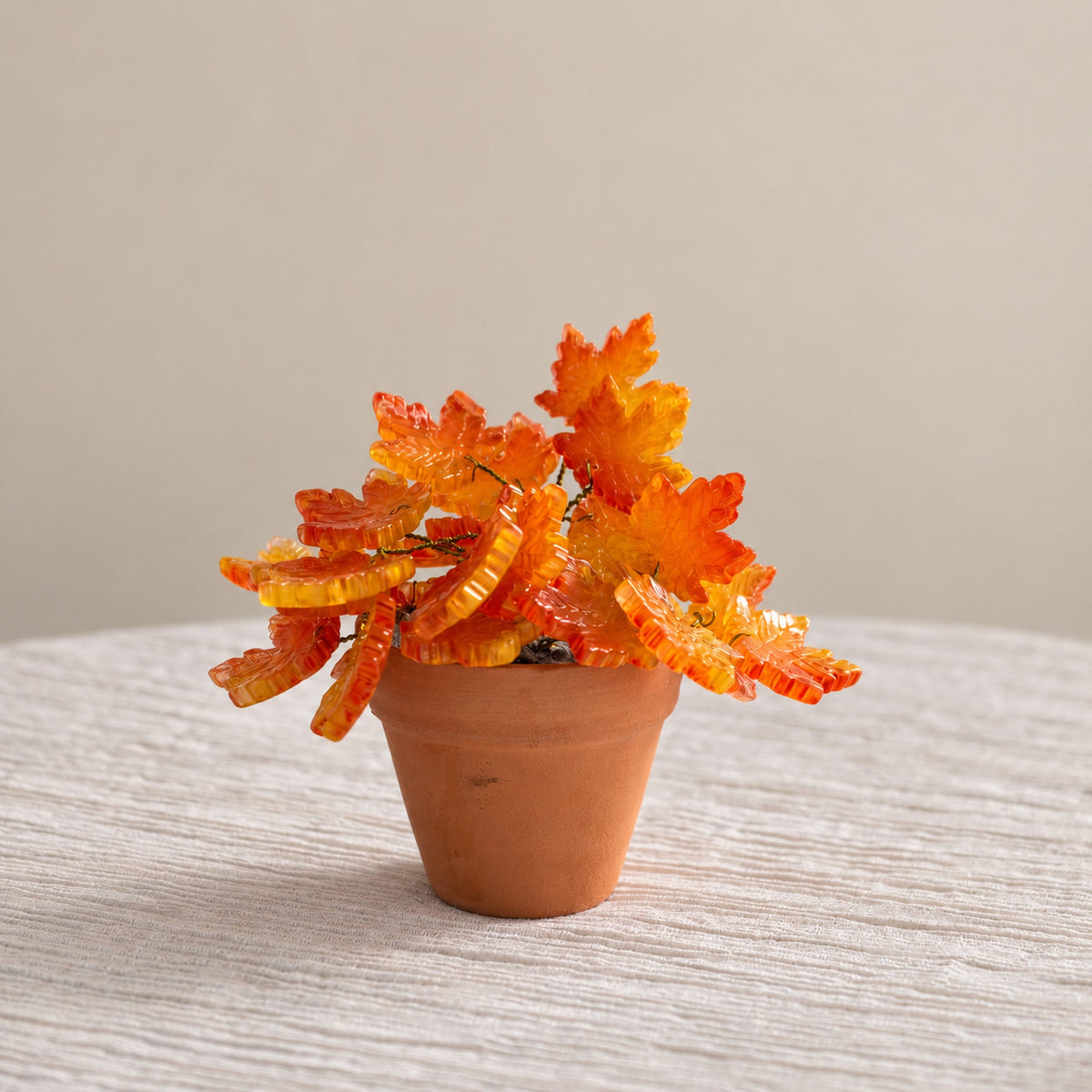 Handmade mini orange maple leaf beaded plant in a terracotta pot