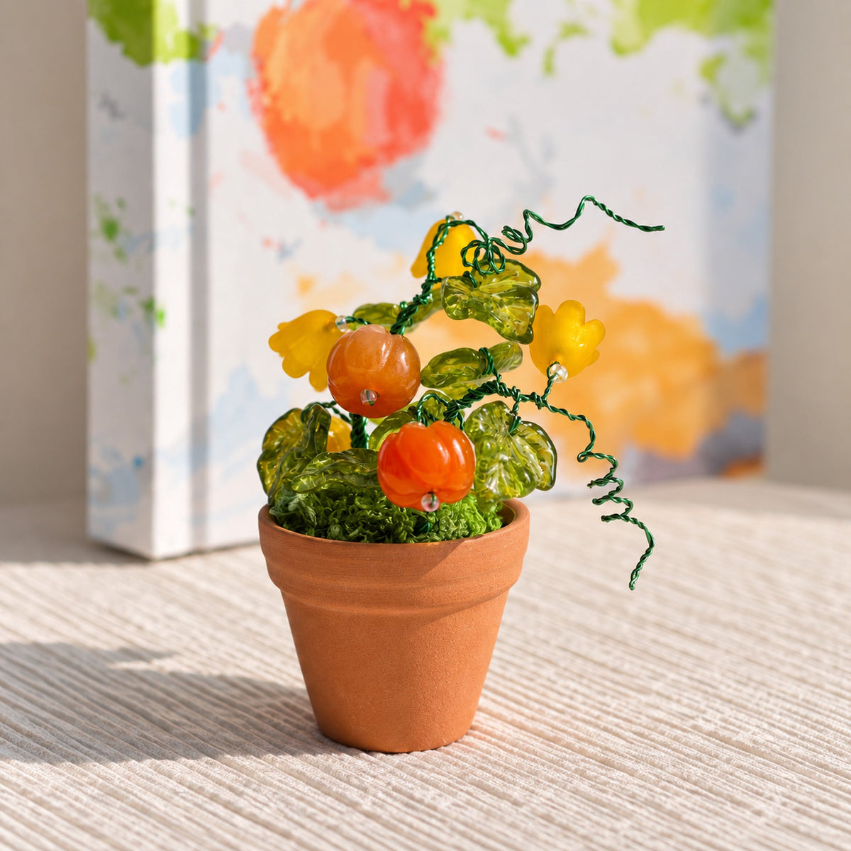 Mini pumpkin and yellow flower beaded plant in warm natural window light