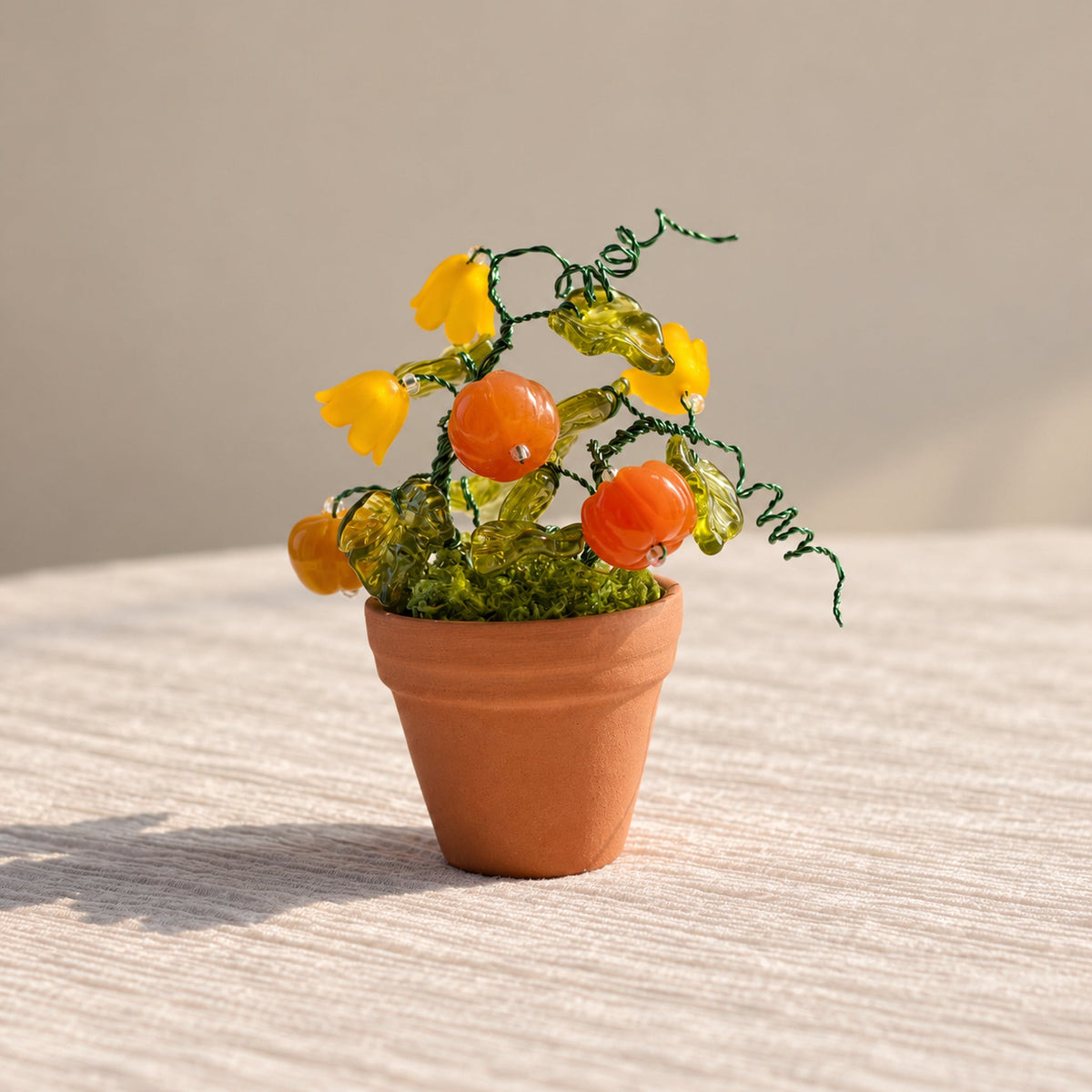 Handmade mini pumpkin beaded plant with yellow glass flowers in a terracotta pot