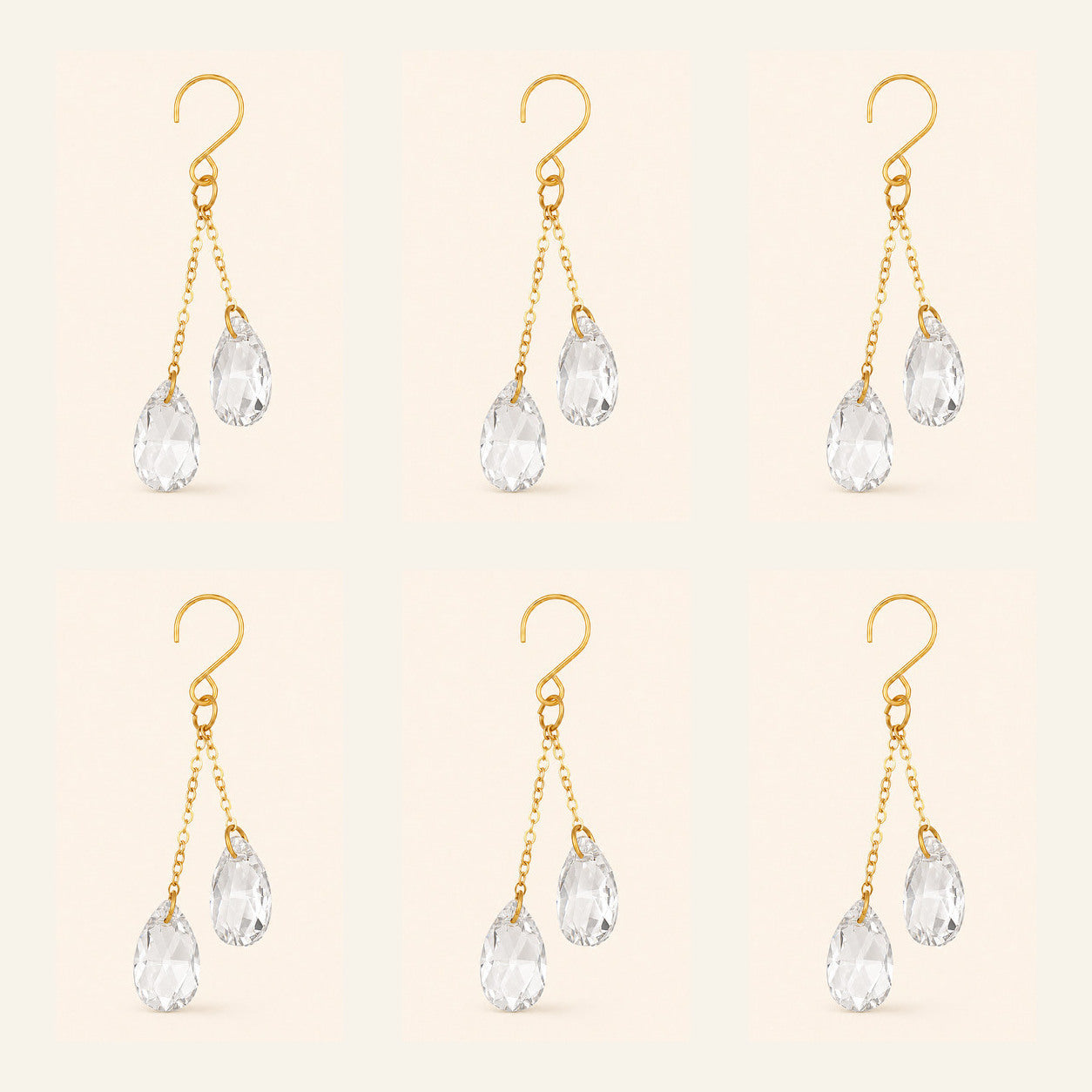 Six clear crystal plant vine suncatcher charms with gold-tone hooks arranged on a warm ivory background.